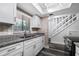Close-up shot of kitchen features granite countertops, stainless steel sink, and a white stairway at 4008 Pine Limb Ct, Tampa, FL 33614