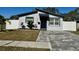 Charming single-story home featuring gray stucco, a brick driveway, and tasteful landscaping at 4029 9Th S Ave, St Petersburg, FL 33711