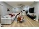 Bright living room with wood floors, white sofa, modern ceiling fan, and large windows at 4029 9Th S Ave, St Petersburg, FL 33711