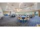 Elegant ballroom with a chandelier, neutral walls, and many round tables with chairs for events at 4495 Secretariat Run, Spring Hill, FL 34609