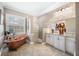 Elegant bathroom featuring a copper soaking tub, walk-in shower, double sink vanity, and decorative finishes at 4495 Secretariat Run, Spring Hill, FL 34609