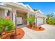Inviting home entrance with double front doors, mature plants, mulch, and an American flag at 4495 Secretariat Run, Spring Hill, FL 34609
