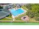 Aerial view of a large pool with lounge chairs, clubhouse, playground, and well-maintained grounds at 4495 Secretariat Run, Spring Hill, FL 34609