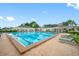 Large pool featuring multiple lap lanes and comfortable lounge chairs for relaxation in a serene setting at 4495 Secretariat Run, Spring Hill, FL 34609