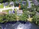 Aerial view of a home with a screened pool, surrounded by mature trees, and backing onto a serene lake at 4617 Basswood St, Land O Lakes, FL 34639