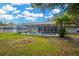 Expansive backyard featuring lush green grass, mature trees, and a screened-in pool area at 4617 Basswood St, Land O Lakes, FL 34639