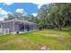 Large backyard offers plenty of space, mature landscaping, and a screened-in pool at 4617 Basswood St, Land O Lakes, FL 34639