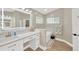 Bright bathroom showcasing a vanity, glass block window, soaking tub and light wood flooring at 4617 Basswood St, Land O Lakes, FL 34639