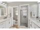 Bright bathroom featuring dual vanities, walk-in shower with glass doors, and tile flooring at 4617 Basswood St, Land O Lakes, FL 34639