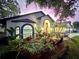 Charming home with lush landscaping, arched windows, and a welcoming entrance, illuminated at twilight at 4617 Basswood St, Land O Lakes, FL 34639
