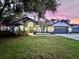 Beautiful home exterior with lush landscaping, arched windows, and double doors, captured at sunset at 4617 Basswood St, Land O Lakes, FL 34639