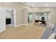 Bright living room featuring light wood floors, a desk, sofa, and arched windows at 4617 Basswood St, Land O Lakes, FL 34639