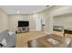 Bright living room featuring light wood floors, a large desk, sofa, and TV at 4617 Basswood St, Land O Lakes, FL 34639