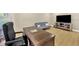 Bright living room featuring light wood floors, a large desk, sofa, and TV at 4617 Basswood St, Land O Lakes, FL 34639