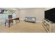 Bright living room featuring light wood floors, a large desk, sofa, and TV at 4617 Basswood St, Land O Lakes, FL 34639
