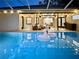 Inviting screened pool featuring swan floats, patio seating, and views of the home's interior at 4617 Basswood St, Land O Lakes, FL 34639