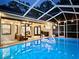 Tranquil screened-in pool area with decorative lighting, patio furniture, and relaxing swan floats at 4617 Basswood St, Land O Lakes, FL 34639