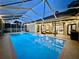 A beautiful pool area under a screened enclosure with string lights and poolside seating at 4617 Basswood St, Land O Lakes, FL 34639