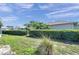View of the backyard with green grass and hedges at 4712 Coachmen Rd, New Port Richey, FL 34655