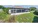 View of the screened patio in the backyard with green grass at 4712 Coachmen Rd, New Port Richey, FL 34655