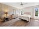Bedroom with wood flooring, ceiling fan, mirror, and two windows at 4712 Coachmen Rd, New Port Richey, FL 34655