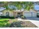 Charming single-story home boasts a manicured lawn and an attached garage at 4712 Coachmen Rd, New Port Richey, FL 34655