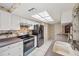 Kitchen offering white cabinets, black appliances, and generous countertop space with stylish wallpaper accents at 4712 Coachmen Rd, New Port Richey, FL 34655