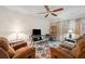 Comfortable living room with a ceiling fan, plush seating, and a colorful rug at 4712 Coachmen Rd, New Port Richey, FL 34655