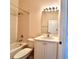 Bright bathroom with a shower-tub combo and a vanity with a white cabinet, topped with a large frameless mirror at 4950 Sandy Brook Cir, Wimauma, FL 33598