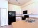 Bright kitchen with white cabinets and black appliances at 4950 Sandy Brook Cir, Wimauma, FL 33598