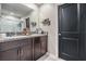 Bathroom with dual sinks, granite counters, and shower with white tile at 5522 Appleton Shore Dr, Apollo Beach, FL 33572
