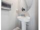 This half bathroom features a white, oval-shaped sink, a round mirror, and a gray and white towel hanging next to it at 5522 Appleton Shore Dr, Apollo Beach, FL 33572