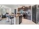 Open kitchen featuring a central island with bar seating, dark cabinets, and stainless steel appliances at 5522 Appleton Shore Dr, Apollo Beach, FL 33572