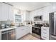 Modern kitchen showcasing white cabinets, stainless steel appliances, and ample counter space at 5632 62Nd N St, St Petersburg, FL 33709