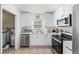 Bright kitchen featuring white cabinetry, stainless steel appliances, and double basin sink at 5632 62Nd N St, St Petersburg, FL 33709