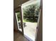 Sliding door leading to the back yard featuring concrete patio, hedge, and shade trees at 5644 Samter Ct, Tampa, FL 33611