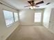 This bedroom features neutral carpet, a ceiling fan and two windows with blinds at 5644 Samter Ct, Tampa, FL 33611