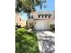 Charming light tan stucco townhome featuring a single-car garage and meticulously maintained landscaping at 5644 Samter Ct, Tampa, FL 33611