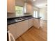Bright kitchen features white cabinets, black countertops and wood laminate flooring at 5644 Samter Ct, Tampa, FL 33611