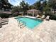 Community pool featuring tiled trim, lounge chairs, and seating under a covered area at 5644 Samter Ct, Tampa, FL 33611
