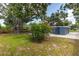 Cozy backyard featuring trees, shrubs, and a small home with a gravel driveway at 6334 22Nd N Ave, St Petersburg, FL 33710