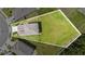 A spacious, green backyard is seen from above with a light-colored home sitting adjacent to two neighboring houses at 6347 Ten Acre Ct, Zephyrhills, FL 33541