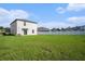 Expansive backyard with lush green grass, white privacy fence, and sliding glass door entry at 6347 Ten Acre Ct, Zephyrhills, FL 33541