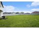 View of the sprawling backyard featuring a lush lawn and secure white privacy fence at 6347 Ten Acre Ct, Zephyrhills, FL 33541