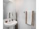 Stylish half bathroom featuring a pedestal sink, decorative accents, and fresh towels at 6347 Ten Acre Ct, Zephyrhills, FL 33541