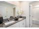Bathroom featuring a double vanity with granite countertop, framed mirror, and a shower-tub combo at 6347 Ten Acre Ct, Zephyrhills, FL 33541