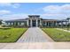 Beautiful clubhouse with manicured lawn, stone pillars, and covered entry at 6347 Ten Acre Ct, Zephyrhills, FL 33541