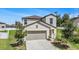 Two-story home with a two-car garage, neutral siding, and a well-manicured lawn at 6347 Ten Acre Ct, Zephyrhills, FL 33541