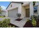 Home featuring a spacious garage, walkway, and landscaped front entrance at 6347 Ten Acre Ct, Zephyrhills, FL 33541
