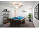 Recreation room with a blue felt billiard table, ceiling fan, adjacent shelves, and unique wall art at 6347 Ten Acre Ct, Zephyrhills, FL 33541